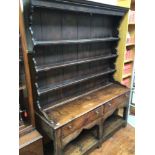 An 18th century stained oak dresser of small proportions, with panelled and shelved raised back with