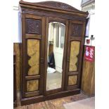 A late Victorian walnut and burr walnut veneered triple-door wardrobe, with central mirrored door