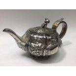 George IV silver teapot of compressed globular form with vertical panelled sides, embossed with