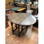 An 18th century stained oak oval drop-leaf gate-leg dining table, with turned supports, 122cm