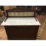 An Edwardian walnut and marble-topped washstand chest, with aesthetic-movement tiled raised splash-