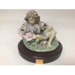 A Lladro porcelain figure of a recumbent sprite amongst flowers holding a butterfly, 'Sprite No.