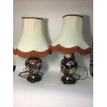 A pair of Oriental style table lamps, of inverted baluster form, decorated with flowers edged with