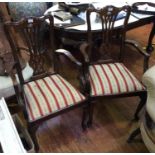 A pair of Edwardian style oak carver chairs, each with pierced back splats, red and gold floral