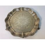 A late Victorian silver salver with piecrust applied rim and foliate engraved centre, raised on