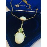 An early 20th century 15ct gold double oval opal and green stone drop pendant on fixed chain, the