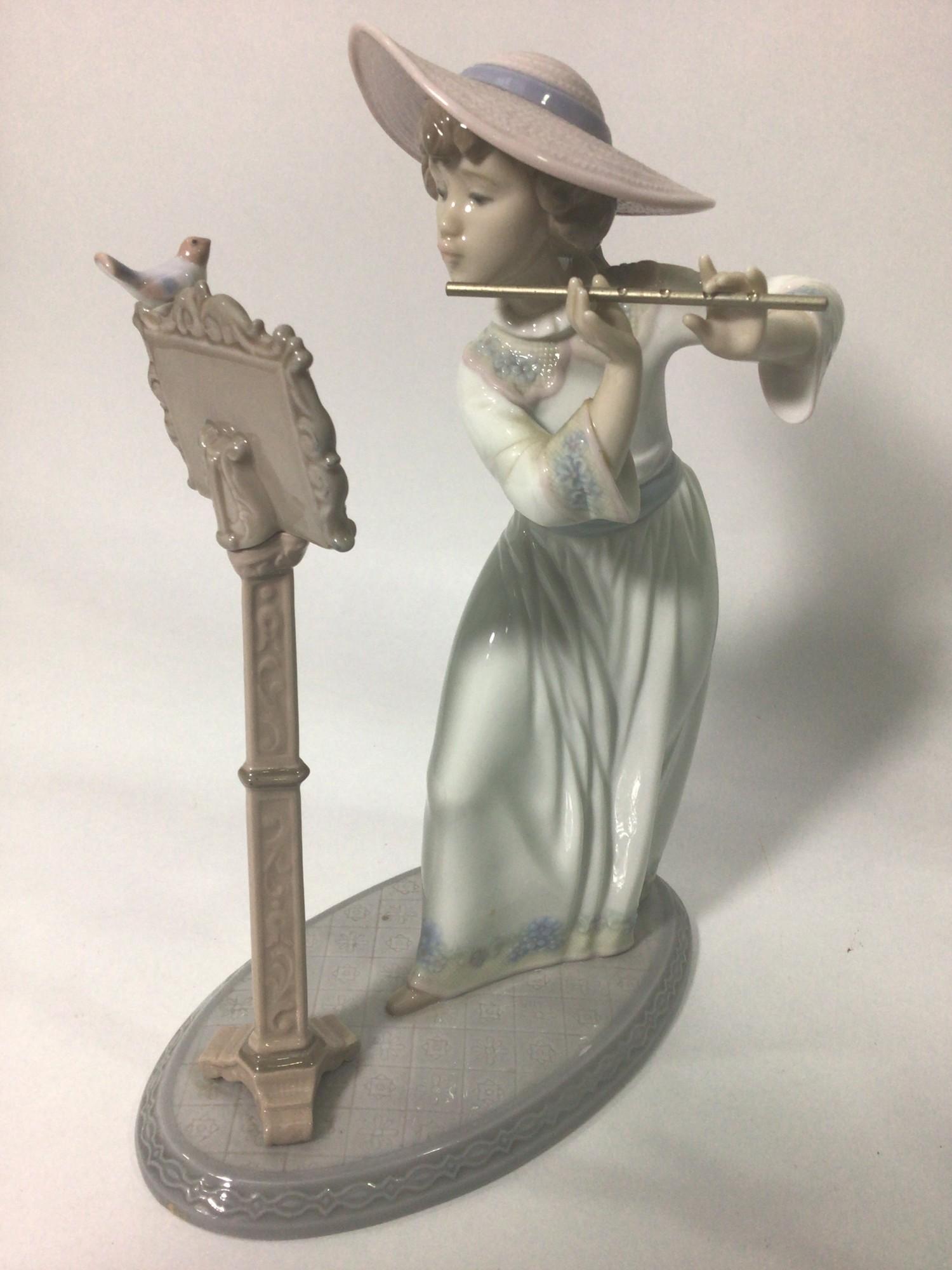 A Lladro porcelain figure of a lady playing the flute, 'Songbird No. 6093', signed to base, 24cm