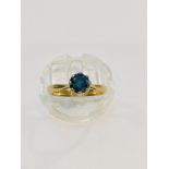 An 18ct yellow gold solitaire blue diamond ring, the round diamond is set in eight platinum claws,