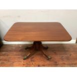 A 20th century mahogany rectangular pedestal table, raised on central column to four splayed