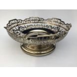A circular silver bowl by James Dixon & Sons Ltd, with pierced, floral sides and raised on spreading