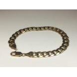 A 9ct solid yellow gold curb link bracelet, weighing 22.8 grams, measures 8.5 inches in length.