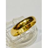 An 18ct yellow gold wedding band, weighing 4.3 grams, 4mm in width, finger size M.