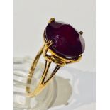 A 9ct yellow gold dress ring, set with a large round cut ruby, measuring 10mm in diameter, ring