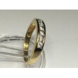 An 18ct yellow gold eternity ring, set with 7 x round brilliant cut diamonds in a channel setting,