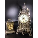 A continental baroque style metal mantel clock of cathedral form, enamel dial with Arabic