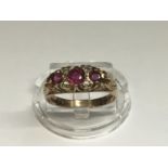 A 9ct yellow gold ruby and diamond ring, set with 3 x oval rubies and 4 x small diamonds, weighing