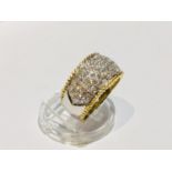 An 18ct white and yellow gold wide band dress ring, set with 59 x round brilliant cut diamonds in