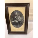 A signed oval monochrome three-quarter-length portrait of King Alfonso XIII of Spain, inscribed in