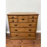 A 20th century oak chest of drawers with a pair of small drawers flanking a larger central drawer,
