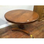 A circular mahogany tilt top supper table, raised on central tapered column, to tripartite base with