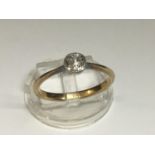 A ladies 18ct yellow gold solitaire diamond ring, set with a round old cut diamond in a rub over