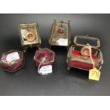 Five assorted religious reliquary pendants, each housed in glazed metal caskets, with annotated