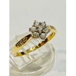 An 18ct yellow gold daisy cluster dress ring, set with 7 x round brilliant cut diamonds in a claw