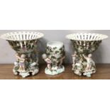 A pair of Sitzendorf figural porcelain comports with pierced bowls, the base with three cherubs