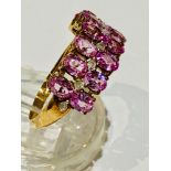 A 9ct yellow gold pink sapphire and diamond dress ring, set with 14 x oval cut pink sapphires in a
