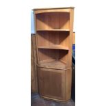 An Ercol light ash standing corner cupboard, with two open shelves above a cupboard, 75cm wide