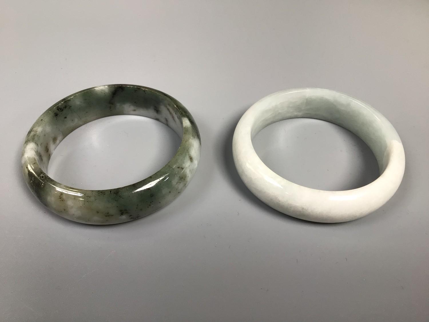 Two various jadeite bangles, the larger one 7cm diameter