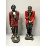 Two various large floor-standing statues, a jazz singer and a trumpet player, both in red jackets,