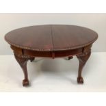 A mahogany extending dining table in George ll style with rounded ends, gadrooned top edge, raised