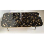 A 1950s black gloss coffee table decorated with gold coloured cocktail glasses, shakers and