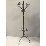 A wrought iron Bentwood style coat stand raised on three arched feet, with mid section for