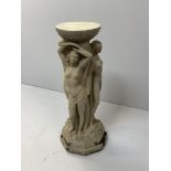 A reconstituted stone figural garden pedestal, with three scantily clad maidens, from the 'Garden of