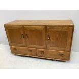 An Ercol light ash sideboard, with three panelled doors enclosing cutlery drawer and shelf, above