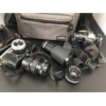 A bag of cameras and lenses including an Olympus OM10, miranda macro 1:3.8-4.8 lens, Tokina 80-