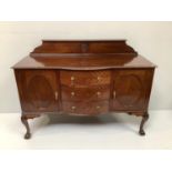 An Edwardian mahogany sideboard in Chippendale style with shaped back floral roundel, bow centre