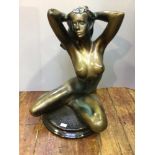A large 'bronzed' resin figure of a seated nude with hands behind her head, on circular base, 55cm
