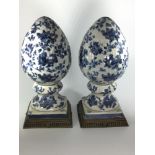 A pair of blue and white porcelain decorative floral acorn shaped finials on square metal bases,