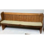 A stripped pine pew with planked backrest and bible rest to back, 183cm long