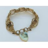 A 9ct yellow gold gate bracelet with engraved heart padlock, weighing 24.2 grams.