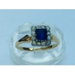 An 18ct gold sapphire and diamond ring, centrally set with a princess cut sapphire measuring 4 x