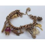 A 9ct yellow gold curb link charm bracelet with 12 x gold charms (and 1 x gold plated charm)