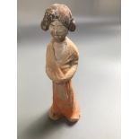 A Chinese earthenware tomb figure of a standing female attendant, remains of black and orange paint,