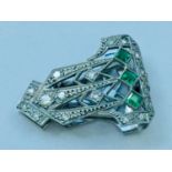 Addendum - missing one stone. A platinum diamond and emerald set clip in the Art-Deco style, weighi