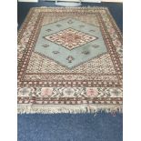 Hand made Caucasian tufted rug, diamond patterned centre on a turquoise background with pink and