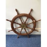 A reproduction eight-spoke ships wheel with brass axle, 94cm diameter