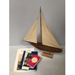 A scratch-built model of a boat with rigged twin sails, raised on plinth base, 73cm high, together